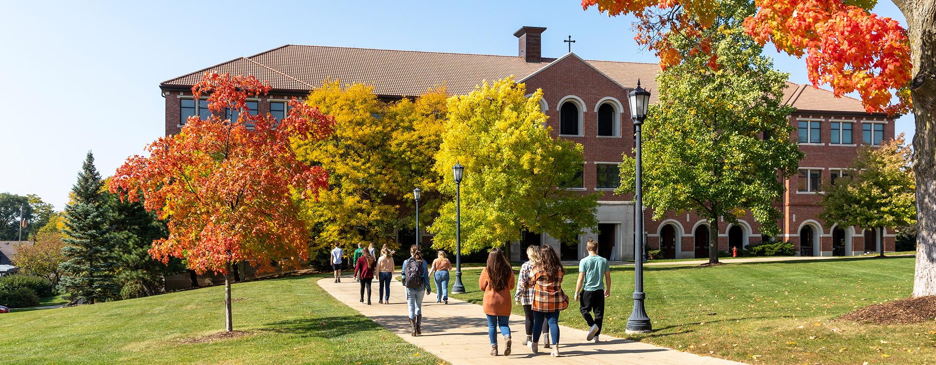 Student walking to Generac Hall during autumn
